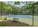 Community tennis courts surrounded by a tall fence and benches at 3275 Cherry Oak Ln, Cumming, GA 30041