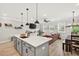 Open-concept kitchen featuring a large island, modern lighting, and a connected living area at 3374 Verdi Ln, Kennesaw, GA 30144