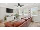 Living room with large windows, ceiling fan, and a comfortable brown leather couch at 3374 Verdi Ln, Kennesaw, GA 30144