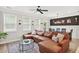 Living room with brown leather couch, large windows, and a view to the dining area at 3374 Verdi Ln, Kennesaw, GA 30144