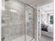 Modern bathroom featuring a glass shower, light tile, and view of a bedroom at 5846 Schelton Se Pl, Mableton, GA 30126
