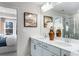 Bathroom boasts double sinks, white cabinets, a decorative mirror, and bedroom access at 5846 Schelton Se Pl, Mableton, GA 30126