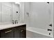 Bathroom with quartz countertop, dark cabinets and white subway tile in tub and shower at 150 Rolison Way, Fayetteville, GA 30214