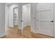 Bright hallway with hardwood floors and views of storage closets and a laundry room at 150 Rolison Way, Fayetteville, GA 30214
