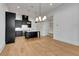 Open concept kitchen with hardwood flooring, stainless steel appliances, modern island, and stylish light fixtures at 150 Rolison Way, Fayetteville, GA 30214