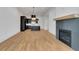Spacious living area featuring hardwood floors, fireplace with herringbone tile surround and modern lighting fixtures at 150 Rolison Way, Fayetteville, GA 30214