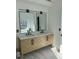 Stylish bathroom featuring a double sink vanity with modern fixtures, large mirrors, and herringbone pattern wood cabinetry at 162 Camden Woods Dr, Dallas, GA 30157
