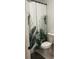 A bathroom showcasing a toilet and a shower curtain with large leafy patterns, offering a simple and functional design at 162 Camden Woods Dr, Dallas, GA 30157