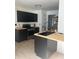 A modern kitchen featuring sleek, black cabinets, light-colored countertops, stainless steel appliances, and wood flooring at 162 Camden Woods Dr, Dallas, GA 30157