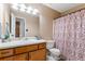 Bathroom featuring a vanity with drawers, adjacent to toilet, and tub with colorful curtain at 200 Pine Tree Ln, Mcdonough, GA 30252