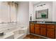 Bathroom showcasing a corner tub and a vanity with wood-tone cabinets and drawers at 200 Pine Tree Ln, Mcdonough, GA 30252