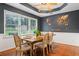Charming dining room featuring a rustic wooden table and bright natural light from large windows at 200 Pine Tree Ln, Mcdonough, GA 30252