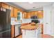Well-lit kitchen with wooden cabinets, stainless steel appliances, and an island with a butcher block top at 200 Pine Tree Ln, Mcdonough, GA 30252