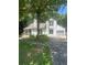 Charming two-story home featuring white siding, a well-maintained lawn, and a lush, mature tree in the front yard at 2500 Trent Dr, Marietta, GA 30066