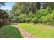 Backyard featuring a stone walkway, green grass, and surrounding greenery at 5510 Stoneybrook Se Ct, Mableton, GA 30126