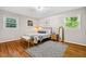 Bright bedroom features hardwood floors, neutral walls, two windows, and stylish decor at 5510 Stoneybrook Se Ct, Mableton, GA 30126