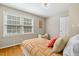 Sunny bedroom featuring hardwood floors, two windows, and cozy reading chair at 5510 Stoneybrook Se Ct, Mableton, GA 30126