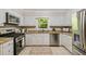Bright kitchen features stainless steel appliances, tile flooring, granite countertops and white cabinets at 5510 Stoneybrook Se Ct, Mableton, GA 30126