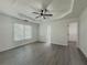 A bedroom featuring a tray ceiling, ceiling fan, a view to the outside and walk-in closet at 2335 Huntington Dr, Loganville, GA 30052