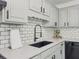 Close-up of a well-appointed kitchen featuring quartz countertops, a black faucet, and subway tile backsplash at 2335 Huntington Dr, Loganville, GA 30052