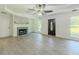 Cozy living room featuring a fireplace with brick surround, gray wood-look flooring, and a modern ceiling fan at 2335 Huntington Dr, Loganville, GA 30052