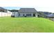 Expansive backyard featuring manicured lawn, partial fencing, and the house's rear facade at 1057 Towne Mill Xing, Canton, GA 30114