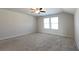 Large carpeted bedroom with ceiling fan, two windows, and neutral colored walls at 1057 Towne Mill Xing, Canton, GA 30114