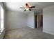 Neutral carpeted bedroom with bright light fixture, window, and a doorway to another room at 1057 Towne Mill Xing, Canton, GA 30114