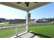 View of the grassy backyard with picket fence from the covered patio with fan at 1057 Towne Mill Xing, Canton, GA 30114