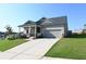 Inviting home featuring a tidy front yard, neutral siding, and an attached two-car garage at 1057 Towne Mill Xing, Canton, GA 30114