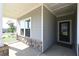 Welcoming front porch with stone accents, gray siding, and a contemporary front door at 1057 Towne Mill Xing, Canton, GA 30114