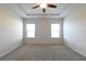 Inviting main bedroom features a tray ceiling, ceiling fan, and neutral walls at 1057 Towne Mill Xing, Canton, GA 30114