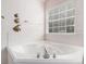 Close up of the bright white garden tub with chrome fixtures, surrounded by tile and decor at 2601 Brandenberry Dr, Decatur, GA 30034