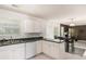 Bright kitchen with white cabinets and an open layout, seamlessly connecting to the dining and living areas at 2601 Brandenberry Dr, Decatur, GA 30034