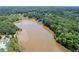 Aerial view of community, lake, and surrounding lush greenery at 2500 Ashbourne Dr, Lawrenceville, GA 30043