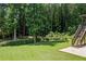 Green backyard and a wooded area can be seen beyond the lawn at 2500 Ashbourne Dr, Lawrenceville, GA 30043