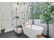Bright bathroom with soaking tub, walk-in shower, modern tile and large arched window at 2500 Ashbourne Dr, Lawrenceville, GA 30043
