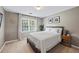 Bright bedroom with neutral walls, carpet, updated lighting, and large window for natural light at 2500 Ashbourne Dr, Lawrenceville, GA 30043