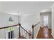 Upstairs hallway with hardwood floors, staircase, large arched window and view of the front door at 2500 Ashbourne Dr, Lawrenceville, GA 30043