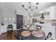 Open kitchen with white cabinets, marble countertops, black chandelier, and a chalkboard with weekly chores at 2500 Ashbourne Dr, Lawrenceville, GA 30043