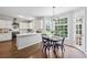 Bright kitchen features white cabinets, stainless steel appliances, and a breakfast nook with large windows at 2500 Ashbourne Dr, Lawrenceville, GA 30043