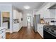 Bright kitchen with white cabinets and appliances, with view of other rooms at 2500 Ashbourne Dr, Lawrenceville, GA 30043