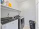 Functional laundry room with washer, dryer, and storage shelf at 2500 Ashbourne Dr, Lawrenceville, GA 30043