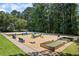 Outdoor recreation area featuring bocce ball, fire pit, and various seating options amid wooded surroundings at 2500 Ashbourne Dr, Lawrenceville, GA 30043