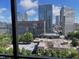 Balcony showcasing urban views, overlooking city buildings and lush green trees at 300 Peachtree Ne St # 11C, Atlanta, GA 30308