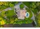 Stunning aerial view of a brick home, showcasing its lush landscaping, private pool, and wooded surroundings at 3505 Watson Rd, Cumming, GA 30028