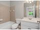 A bathroom with neutral tiled walls features a vanity with white cabinets and a toilet at 3505 Watson Rd, Cumming, GA 30028