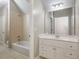 Well-lit bathroom featuring a shower and tub combo with tile surround, and a white vanity at 3505 Watson Rd, Cumming, GA 30028