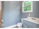 Powder room featuring a gray cabinet and white sink with a window at 3505 Watson Rd, Cumming, GA 30028