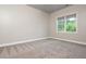 A light-filled bedroom with carpet features a large window providing ample natural light at 3505 Watson Rd, Cumming, GA 30028